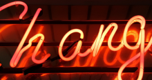 Neon light in red that says "Change"