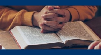 Hand clasps over a bible