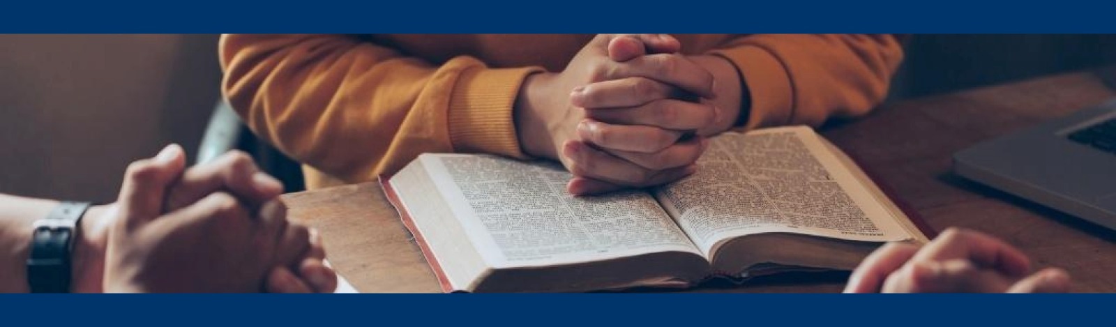 Hand clasps over a bible