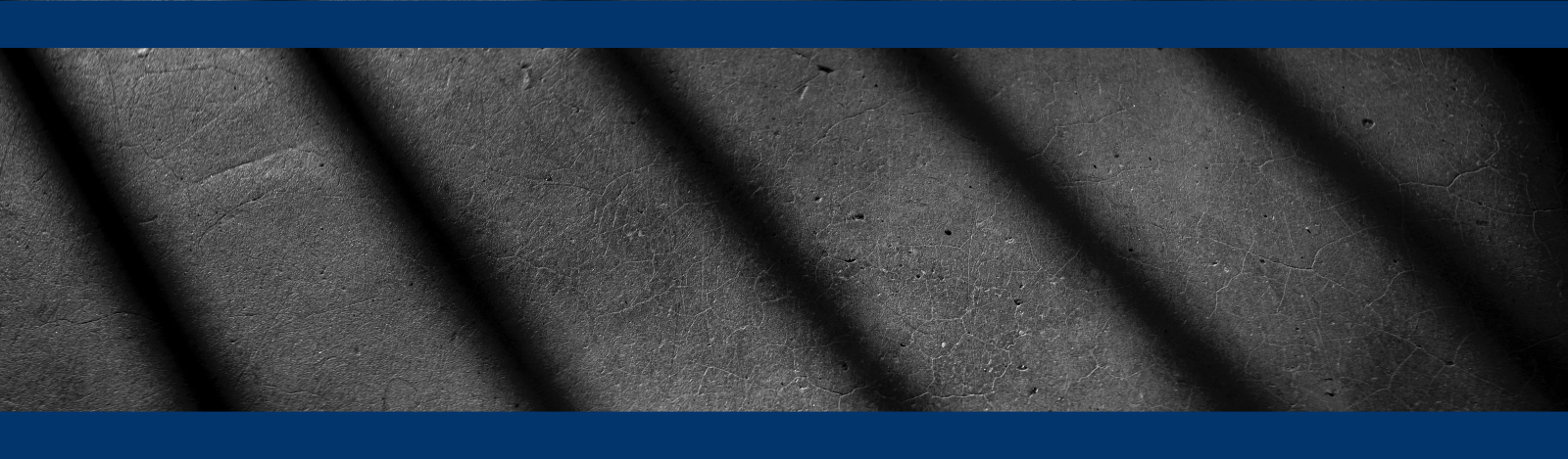 Shadow on jail cell bars on asphalt